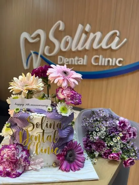 A 7th-anniversary cake and flowers in front of the Solina wave sign