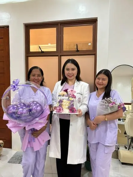 Doc Kath and two assistants in lavender scrubs celebrating the clinic’s 7th anniversary