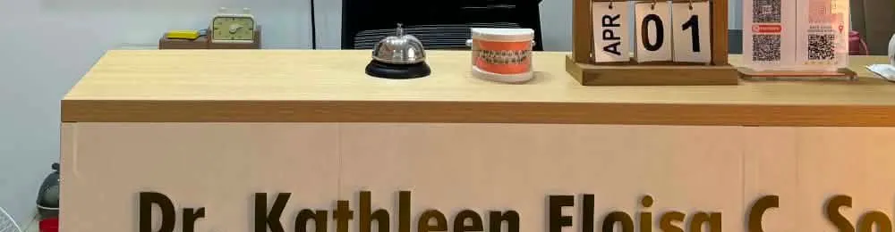 The nameplate on the clinic reception desk: Dr. Kathleen Eloisa C. Solina-Cruz, Dentist